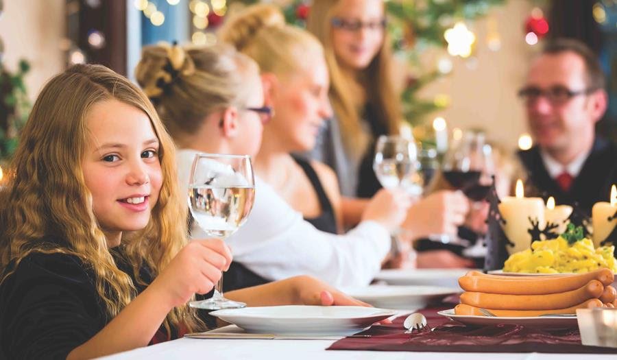 Kid drinking glass of water at dinner