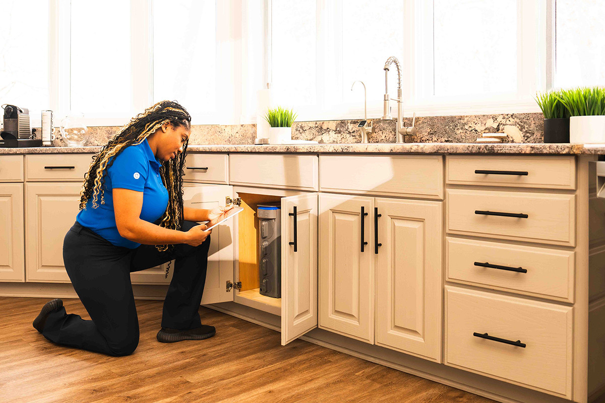 Culligan woman servicing a reverse osmosis system